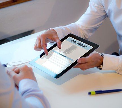 Team member showing patient dental insurance forms on tablet computer