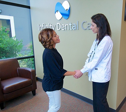 Dr. Kalluri shaking hands with dental patient