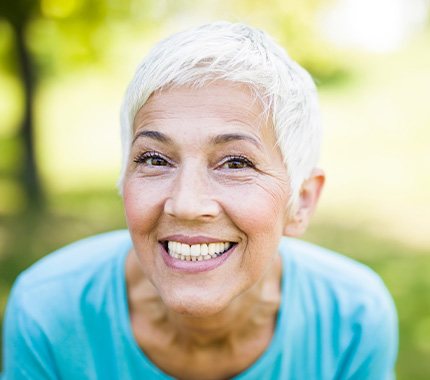 Senior woman in blue shirt smiling outside