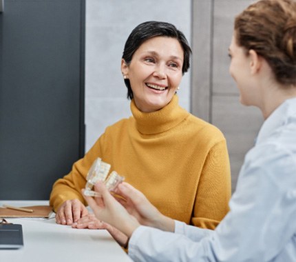 woman talking with a dental professional about replacement options