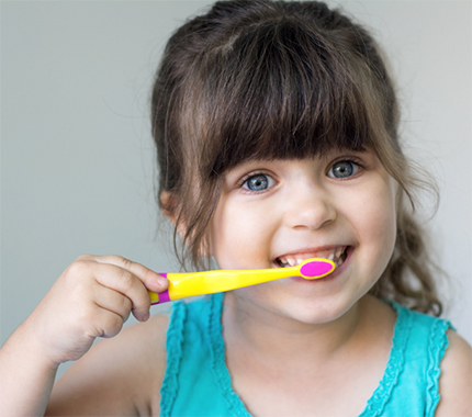 A little girl brushing her teeth