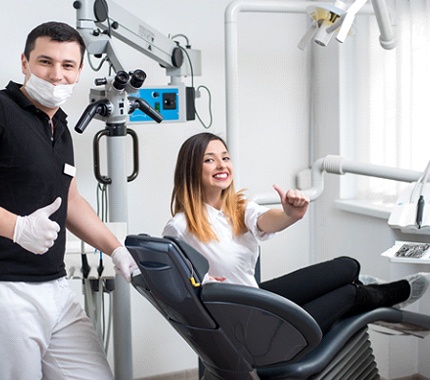 Woman and dentist giving thumbs up