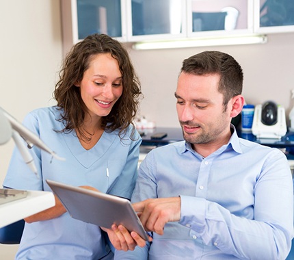 Dentist explaining the cost of treating dental emergencies in Hillsboro