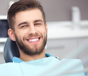 Happy male patient attending checkup at dentist’s office