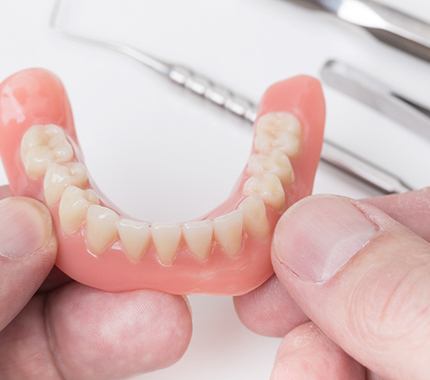 Older woman with beautiful smile giving thumbs up for immediate dentures