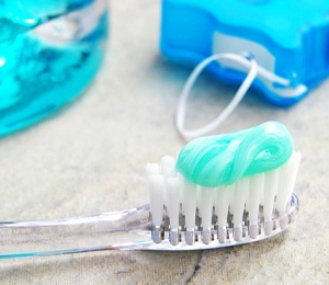 A man stands in front of his bathroom mirror and brushes his teeth in the morning