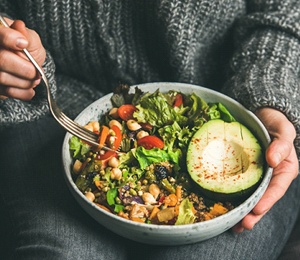 An older couple making a salad together to ensure a healthy diet