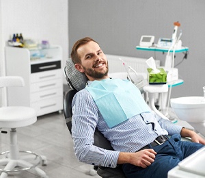 A man listens closely to his dentist during a regular checkup after receiving dental implants