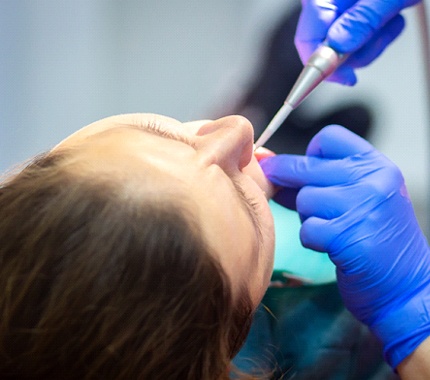 A female patient fully sedated while undergoing a dental procedure