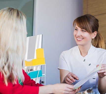 Dental patient checking in at reception desk