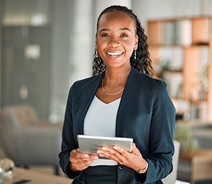 Woman smiling while holding tablet