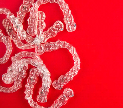 Invisalign clear aligners on red background 