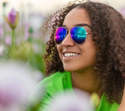 Woman with sunglasses and beautiful smile after smile makeover in Hillsboro 