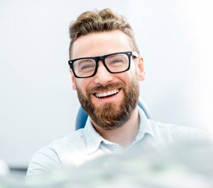 man smiling and speaking with dentist in Hillsboro