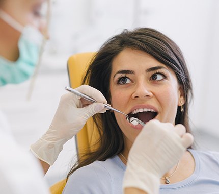 Dentist checking woman’s mouth before periodontal therapy