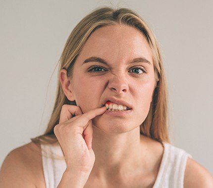 Woman pointing to her inflamed gum tissue