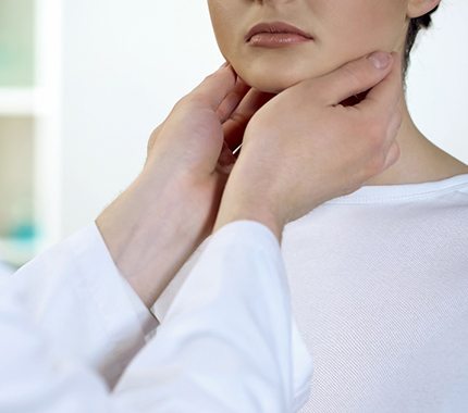 Dental team member feeling lymph nodes during oral cancer screening