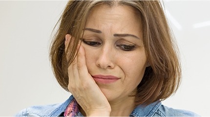 Woman in pain holding jaw