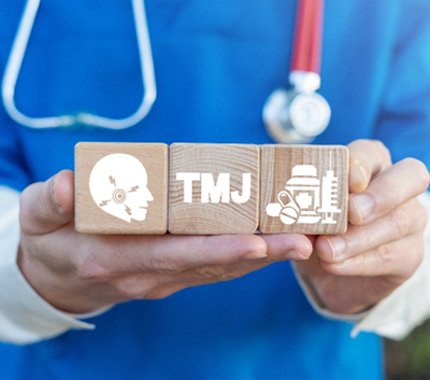 A dentist holding blocks representing TMJ disorder