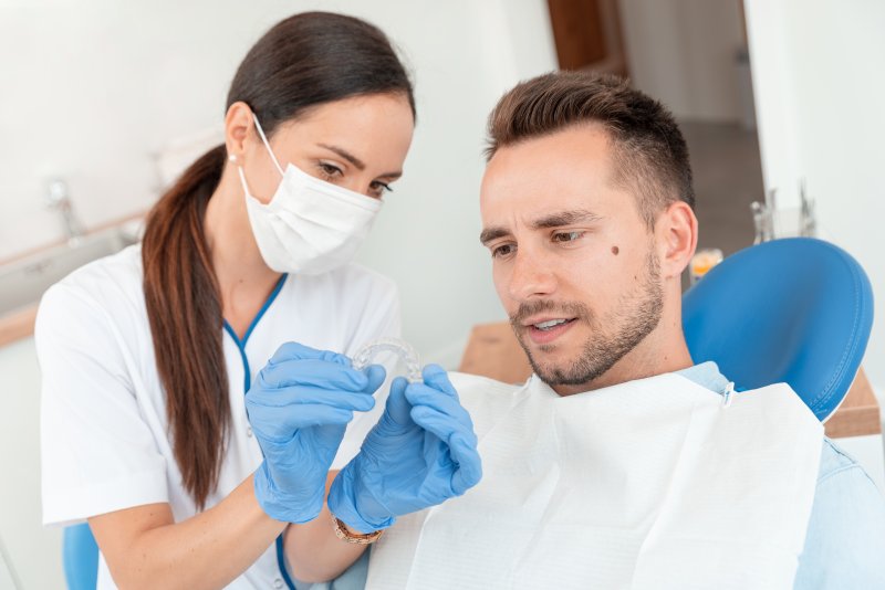 A dentist showing a patient how to get Invisalign after braces